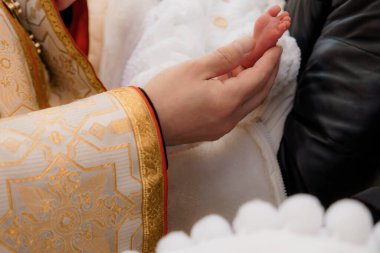 Bir Şefkat Anı: Bir Rahibin Vaftiz Törenindeki Bebek Ayağını Kutsaması.