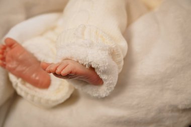 Yumuşak örgü ile sarılmış bebek parmakları.