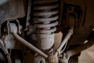 Araç Emici, Bobin Yayı ve Kontrol Kolları Gösteren Tozlu ve Paslı Süspansiyon Sistemi 'nin Yakın Görüntüsü.