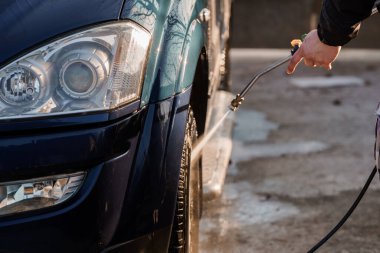 Açık Beton Yüzeye Yüksek Basınçlı Su Spreyle Temizlenen Bir Arabanın Detaylı Görünümü.