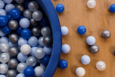 Ahşap yüzeyde Mavi Havuzda Mavi, Gri ve Beyaz Plastik Toplar.