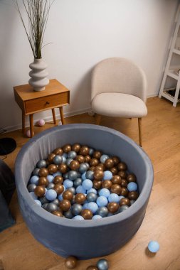 Mavi, Kahverengi ve Gümüş Toplarla Dolu Konforlu Oturma ve Şık Top Havuzu.