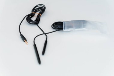 Çift Eklenti Bağlantısı olan izole Ses Kablosu Beyaz Yüzeydeki Plastik Paketlemede Kısmen Depolandı.