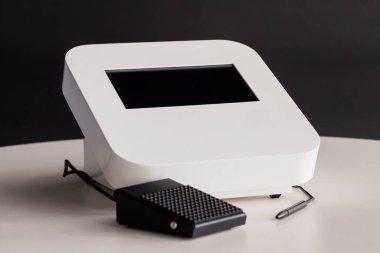Dokunmatik Ekranlı Modern Elektronik Aygıt ve Beyaz Masada Ayak Pedalı.