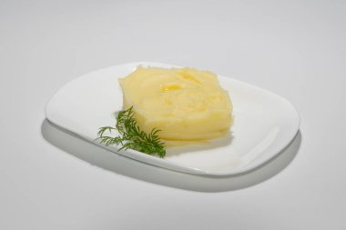 Kremalı Patates püresi Beyaz Seramik Tabakta Taze Dil ile süslenmiş.