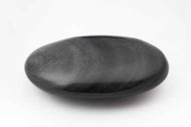 Beyaz zemin üzerinde izole siyah kar obsidiyen taş, pürüzsüz yuvarlak çakıl taşı, mineral numunesi.
