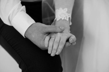 Samimi Düğün Anı: Damat Tutma Gelinin Eli Siyah ve Beyaz Yüzüklerle Evlilik Yüzüklerini Gösterme Aşkı ve Bağlılığı simgeliyor.