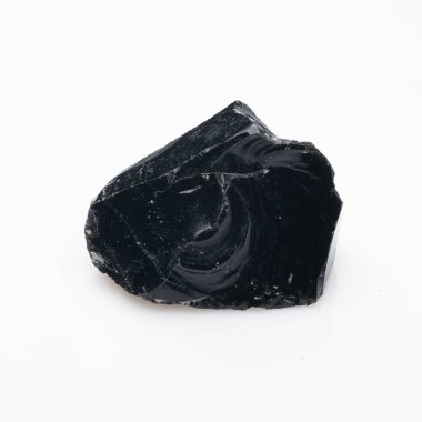 Kaba, siyah obsidyen bir kaya parçasının yakın çekim görüntüsü parlak, yansıtıcı bir yüzey, girdap desenleri ve düz beyaz bir arkaplana karşı keskin, çatlak bir kenar..