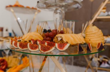 Zarif meyve ve peynir tabağı sunumu, incir, üzüm, armut ve bal peteği sunumu, lüks bir etkinlik için tasarlanmış ya da ikram edilen.