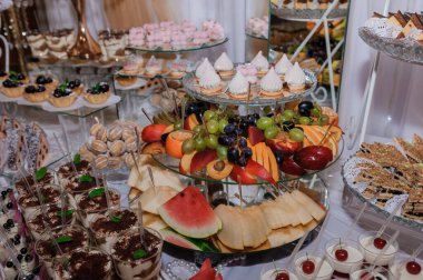 Pastalar, pastalar, taze meyveler ve tiramisu gibi çeşitli tatlı çeşitleri ile dolu lüks bir tatlı masası..