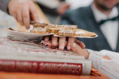 Geleneksel bir ekmek kırma törenine ev sahipliği yapan samimi düğün anı güzel dekore edilmiş bir tabak ve haritayla iki el birlik ve kültür mirasını sembolize ediyor..