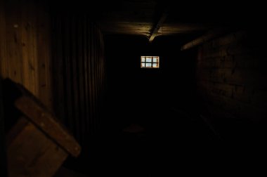 Loş, sade, ahşap bir iç döşeme, küçük kare bir pencere, yumuşak bir parıltı yayıyor, karanlık ve aydınlık tünel kabini odunu arasında katı bir kontrast oluşturuyor..