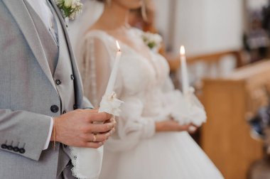 Gelin ve damadın dini bir tören sırasında mum tutarak bir kilise ortamında birlik ve bağlılıklarını sergiledikleri yürek ısıtan bir düğün sahnesi..