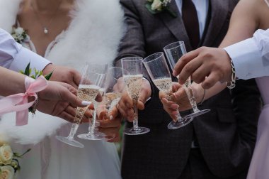 Gelin, damat ve sevdiklerinin kutlamaları için şampanya bardaklarıyla neşeli bir düğün kadehi. Sıcak ve şenlikli bir atmosfer yaratıyorlar..