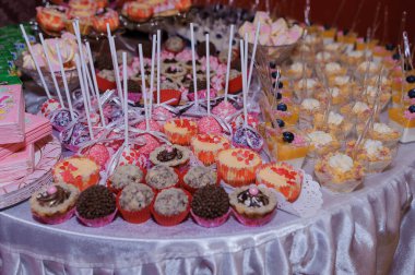 Müsrif pembe bir tatlı masası çikolatalar, kekler, kekler ve meyveli kekler ile dolup taşıyor. Neşeli bir parti için mükemmel.