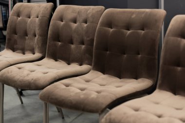 Bir sıra zarif, kahverengi kadife yemek sandalyeleri, düğme tokuşturma ve ince metal bacaklar, restoranlar ve modern evler için lüks ve rahat bir oturma düzeni sunar.