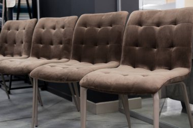 Minimalist modern bir iç mekanda sıralanmış dört adet kahverengi kadife yemek sandalyesi, rahat ve şık bir mobilya düzenlemesi izlenimi uyandırıyor.