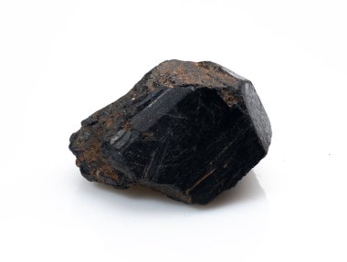 Yakın plan bir görüntüde sert, siyah bir turmalin kristal numunesi bulunur. Işığı yansıtan doğal bir yüzeyi vardır. Genellikle topraklama ve iyileştirme için kullanılır.