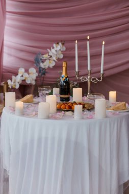 Özel pembe tonlu sahneler şampanya, mum ve çiçeklerle dolu bir kutlama masası romantik durumlar, yıldönümleri ya da evlenme teklifleri için mükemmel.