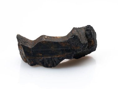 Kaba, işlenmemiş siyah bir turmalin kristal parçası belirgin bir şekilde beyaz bir arkaplan karşısında duruyor, doğal, çizgili dokusu ve derin, gölgeli rengi sergiliyor.