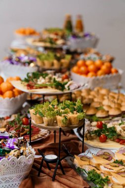 Bu resim renkli meyveler, mini çörekler ve lezzetli atıştırmalıklar da dahil olmak üzere lezzetli mezelerin bolluğuyla dolu canlı bir bayram büfesi sergiliyor.