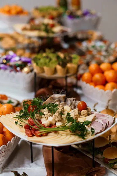 Şarküteri, peynir, canlı domates ve baharatlı jambonu beyaz keten kaplı bir masa üzerinde, partiler ve gurme yemekleri için ideal bir şekilde bol bol düzenleyin.