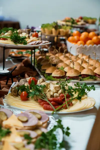 Şişe, taze meyve, peynir ve çeşitli parti yemekleri üzerine mini burgerler dahil nefis aperatifler sergilenen müsrif bir açık büfe. Etkinlikler için mükemmel.