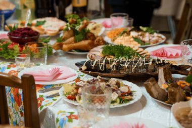 Zengin bir masa, canlı bir Ukrayna ziyafeti sunuyor. Tabaklar dolusu füme balık, salata, hamur işleri ve geleneksel yemekler.