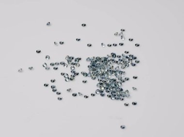 Mücevher tasarımı, mücevher ayarı ve kristal estetik projeler için ideal açık gri bir yüzeye saçılmış küçük, doğal mavi safir koleksiyonu.