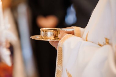 Katolik ayini sırasında bir rahibin ayin sunduğu dini bir sahne. Paten, beyaz cübbe, kutsal dini ayin ev sahibi Altın Kadeh.