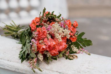 Şeftali ve mercan gülünün büyüleyici bir görüntüsü narin kır çiçekleri ve yüzüklerle süslenmiş, aşkı ve bağlılığı simgeliyor.