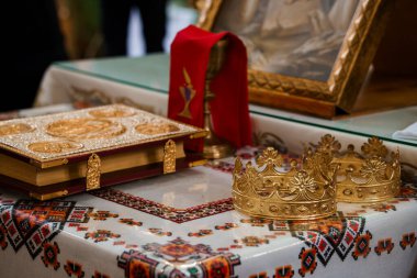 Titizlikle düzenlenmiş dini bir sahne altın bir taç, süslü bir incil ve kutsal bir kadeh sunar. Örtülü bir bez parçasıyla kaplı. İnanç ve maneviyatla.