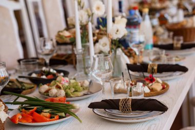Güzel düzenlenmiş bir düğün ziyafeti masasında taze beyaz örtüler, narin çiçekler ve bol miktarda taze yemek tabakları sergilenir. Sıcak ve kutlayıcı bir atmosfer yakalarlar.