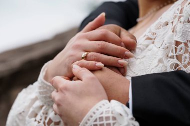 Romantik bir kutlama sırasında alyansların birbirine yakın durması. Güzel dantelli bir gelinlik ve bağlılığı sembolize eden altın yüzükler.