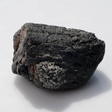 Kaba, doğal olarak oluşmuş bir siyah turmalin kristal parçasının yakından görüntüsü granüler eklentiler ve benekli turuncu gölgeler, jeoloji için mükemmel, değerli taşlar, iyileştirme