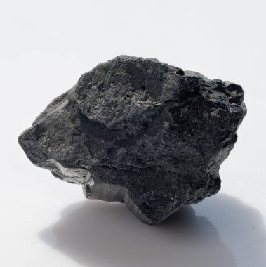 Kaba, siyah bir turmalin kristal kayanın temiz beyaz arka planda izole edilmiş yakın çekimi. Bu mineral numunesi metafizik kullanım ve mücevher yapımı için idealdir.