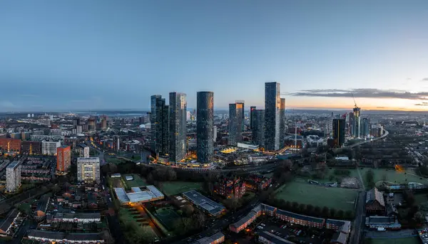 stock image Aerial of Deansgate Square Manchester UK in the blue zone just before sunrise.Deansgate Square South Tower,The current legal building name Trinity Islands Building D2 ,Deansgate Square East Tower, Three60, The Blade, Elizabeth Tower,