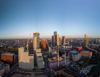 Karanlık şehri bir geçiş evresinde yakalıyor, gökyüzü hala son ışığı tutuyor ve binalar içeriden parlamaya başlıyor.