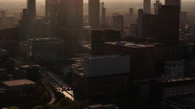 Günbatımında Manchester City Skyline: Otoyol Trafik ve Puslu Şehir Manzaralı Kentsel Hava Görüntüsü