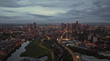 Manchester City 'nin Alacakaranlıktaki Hava Görüntüsü: Binalar, Nehir ve Tren Raylarıyla Şehir Manzarası