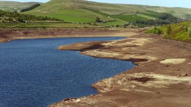 Büyük Manchester 'a içme suyu sağlayan sistemin bir parçası olan rezervuar, kuraklık şartları sırasında belirgin derecede düşük olan Woodhead rezervuarının havadan görünüşü, Haziran 2025' te Kuzey Derbyshire 'da yer almaktadır.