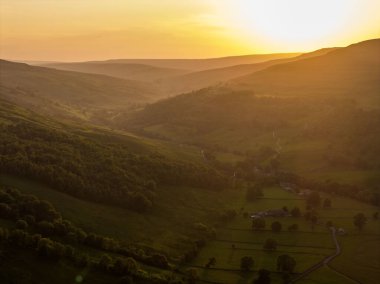 Yorkshire Dales 'deki Buckden Köyü' nün çarpıcı hava manzaralı tarlaları akşam güneşinde yıkandı.
