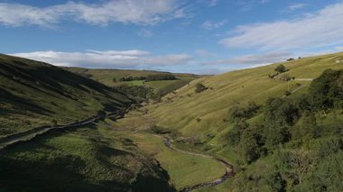 Kettlewell, Yukarı Wharfedale, Yorkshire Dales, İngiltere 'de dolambaçlı bir akarsu ile Sersemletici Yeşil Vadi Panoramik Drone Manzarası.