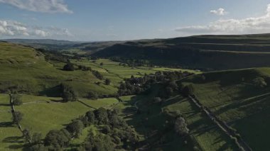 Kettlewell, Yukarı Wharfedale, Yorkshire Dales, İngiltere 'de dolambaçlı bir akarsu ile Sersemletici Yeşil Vadi Panoramik Drone Manzarası.