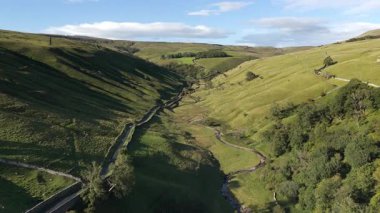 Kettlewell, Yukarı Wharfedale, Yorkshire Dales, İngiltere 'de dolambaçlı bir akarsu ile Sersemletici Yeşil Vadi Panoramik Drone Manzarası.