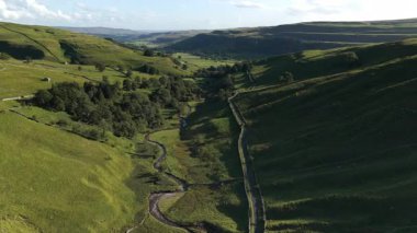 Kettlewell, Yukarı Wharfedale, Yorkshire Dales, İngiltere 'de dolambaçlı bir akarsu ile Sersemletici Yeşil Vadi Panoramik Drone Manzarası.