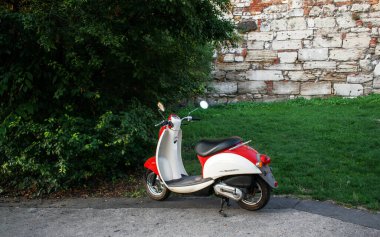 Parke taşlarının üzerinde kırmızı bir moped. kırmızı ruh hali