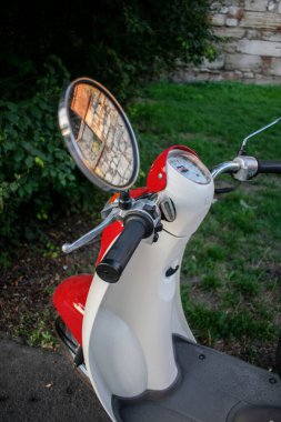 Parke taşlarının üzerinde kırmızı bir moped. kırmızı ruh hali