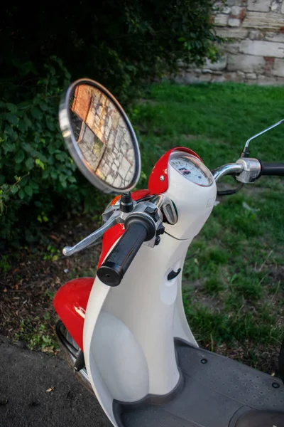 Parke taşlarının üzerinde kırmızı bir moped. kırmızı ruh hali