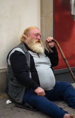 Caddede oturan sevimli yaşlı adam.